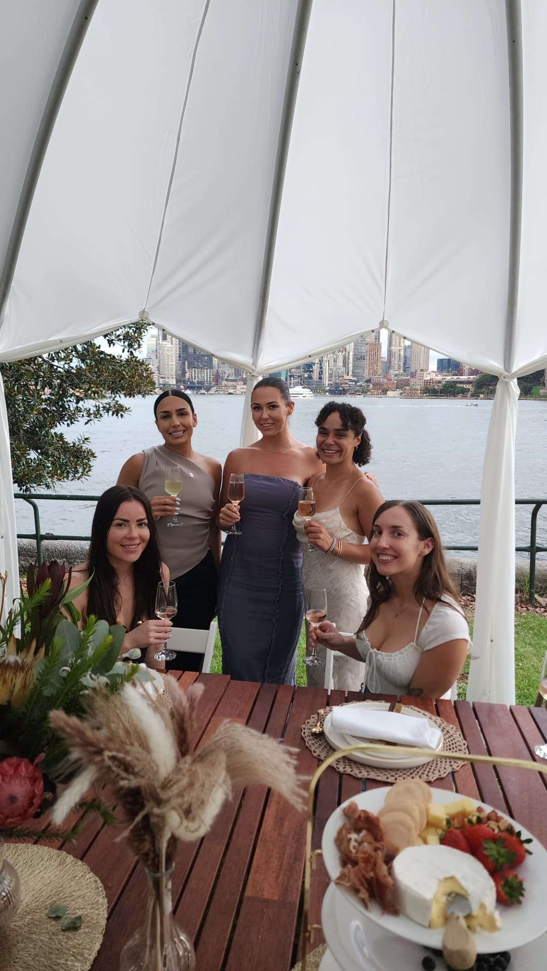 Guests celebrating under an IGLOOZE cabana with a harbour skyline view