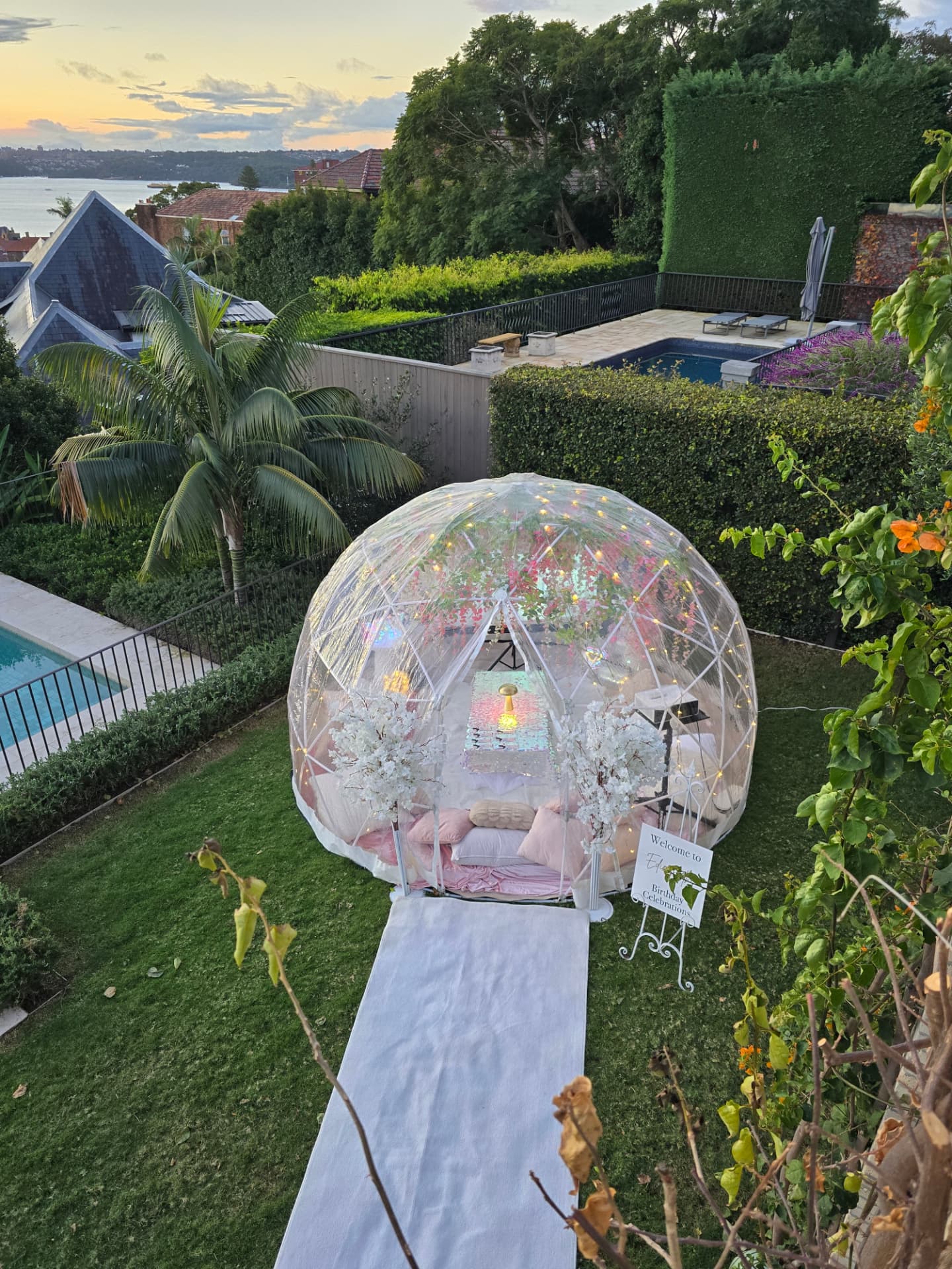 IGLOOZE dome set up in a garden at dusk for a birthday celebration