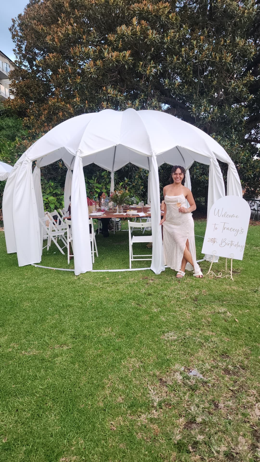 IGLOOZE white dome set up on a lawn for a birthday celebration with a welcome sign